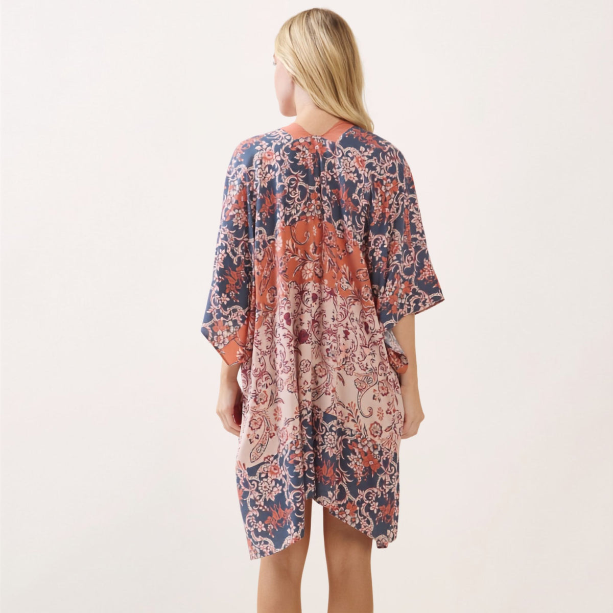 Back view of the paisley-floral print kimono in navy, terracotta, and cream, showing the full pattern and coral trim.