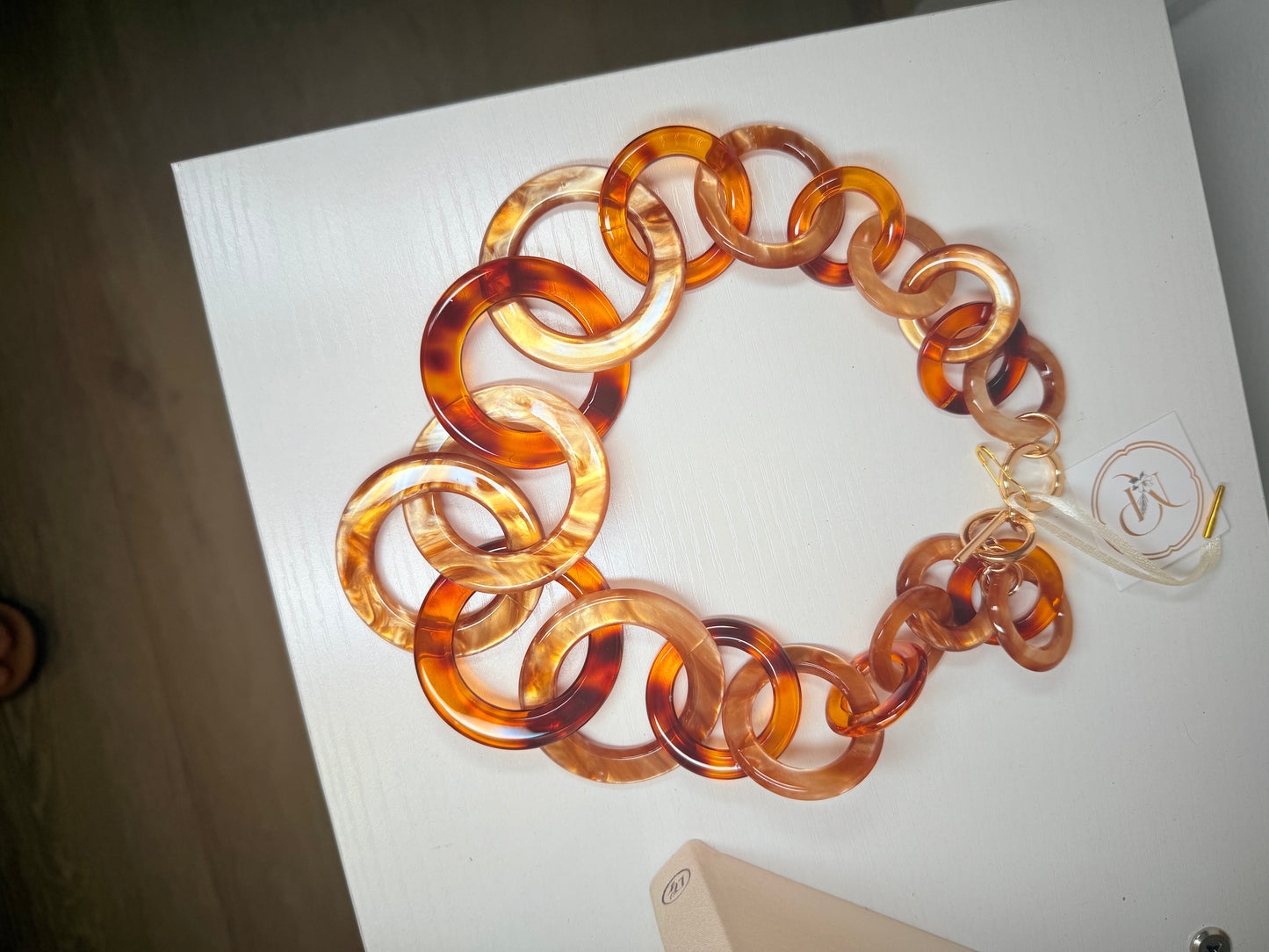 Resin Circle Necklace in brown resin, laid flat showing circular link design