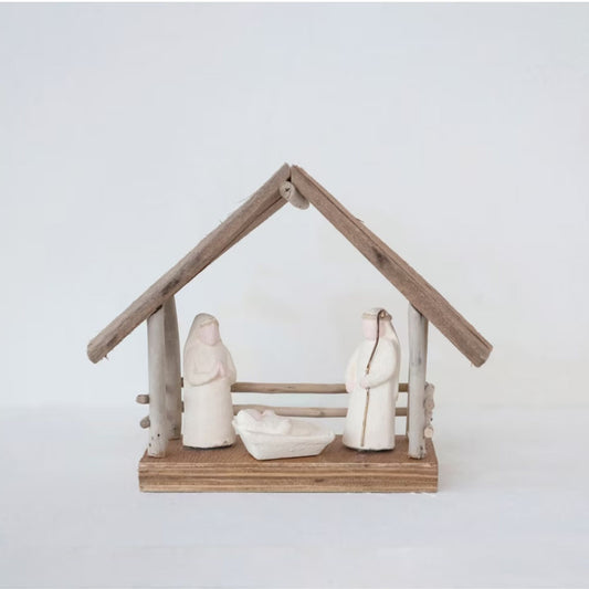 Close-up of the driftwood and paper mache nativity figures on a natural wood base.