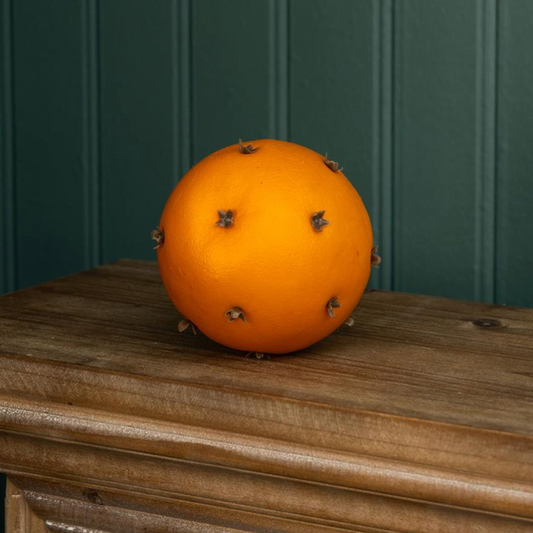 Orange fruit with small spikes on a wooden surface against a green paneled wall