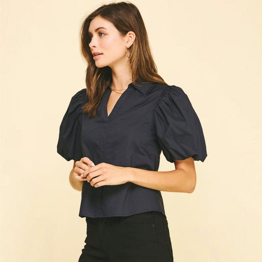 Side view of a black blouse with dramatic puff sleeves and a V-neckline.