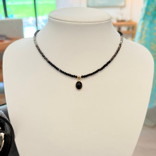 Black beaded choker necklace with a faceted black stone pendant in a gold setting