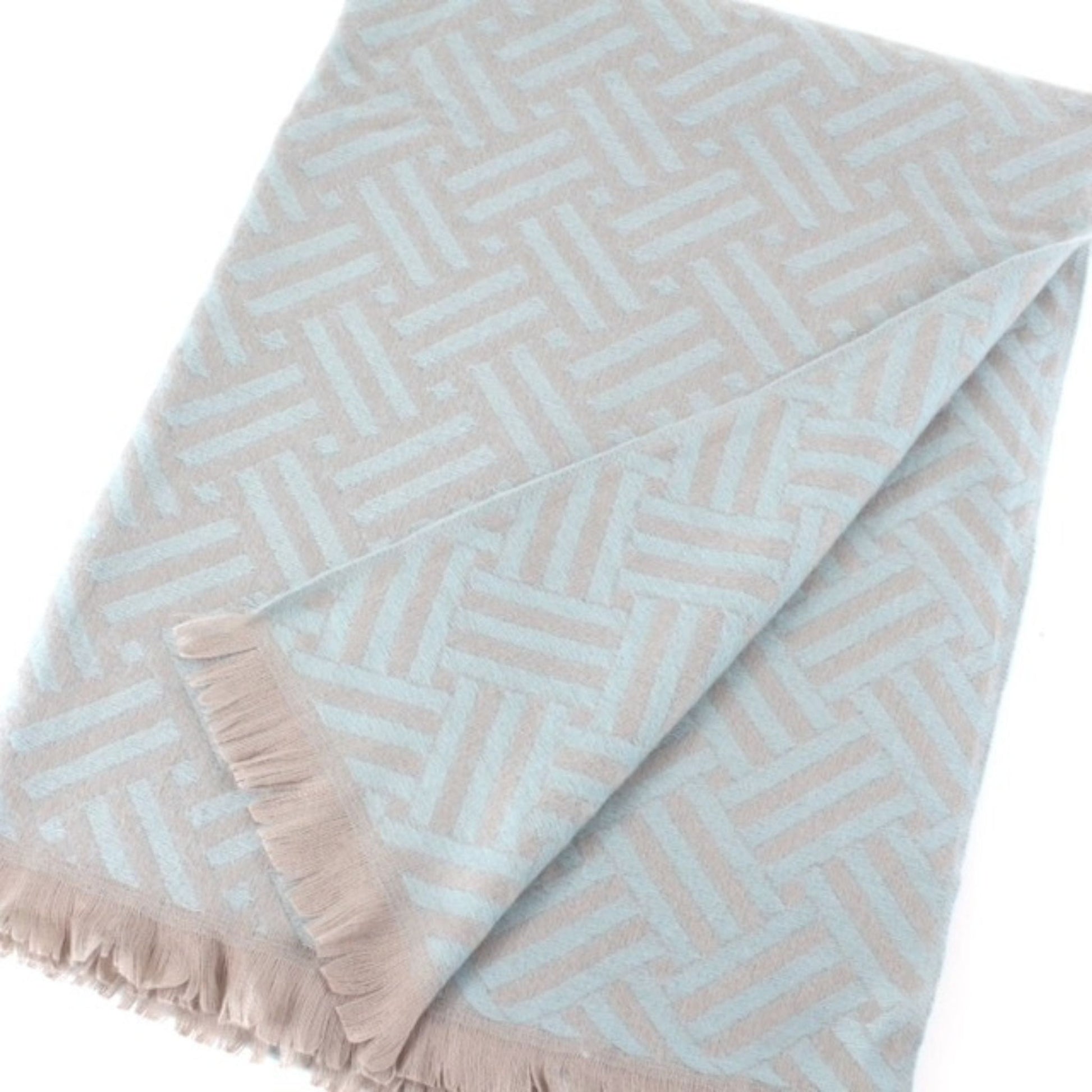 Blue patterned reversible scarf wrapped around a bag's handles