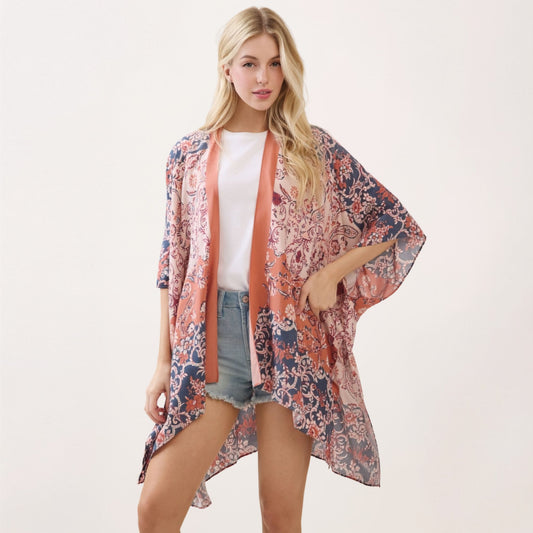 A model wearing the navy and terracotta paisley-floral print kimono, front view with coral neckline tie visible.