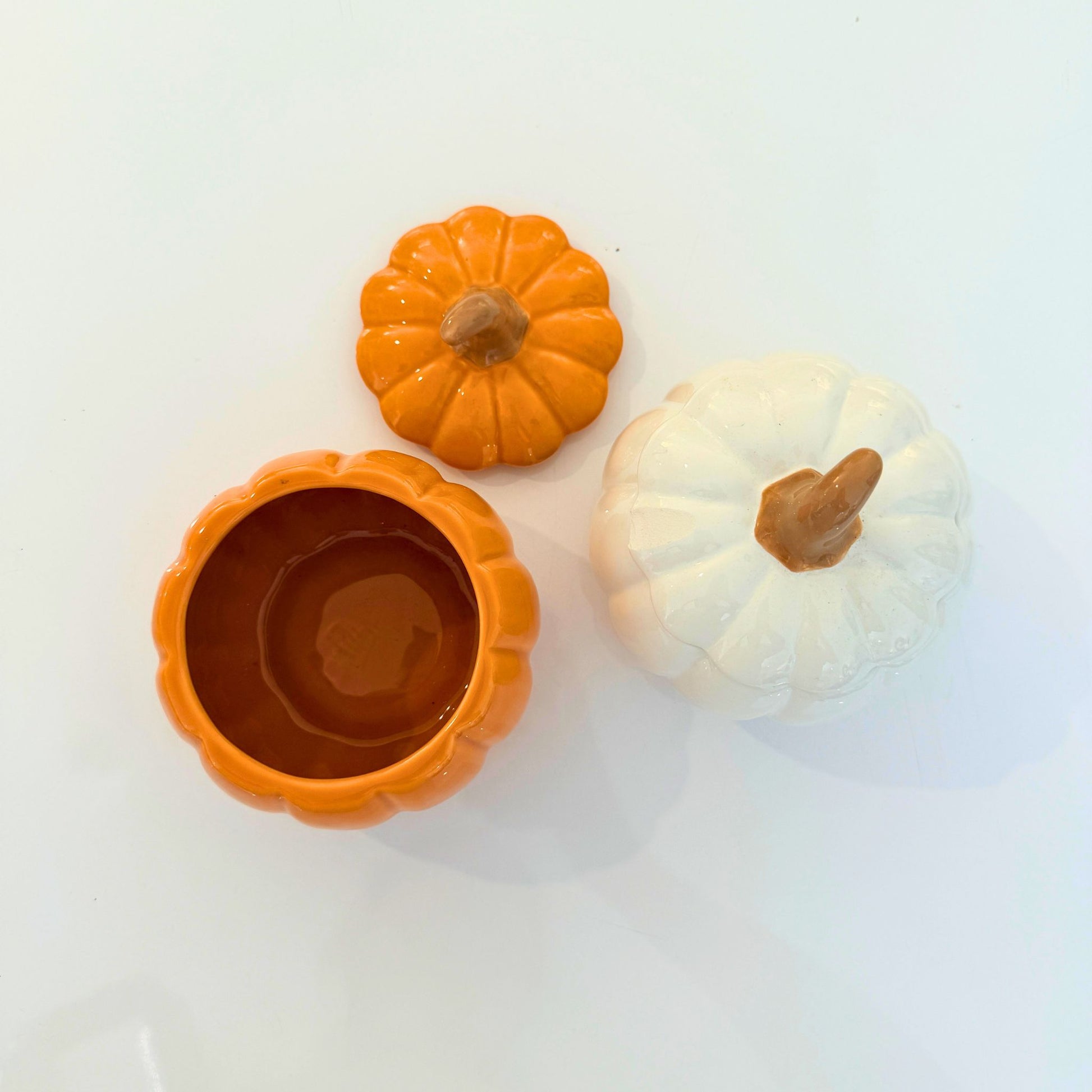Orange and white ceramic pumpkin jars styled together on a table