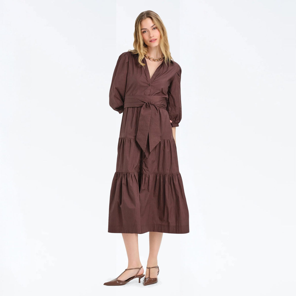 Woman wearing a cocoa brown tiered maxi shirtdress with a tie waist, front view