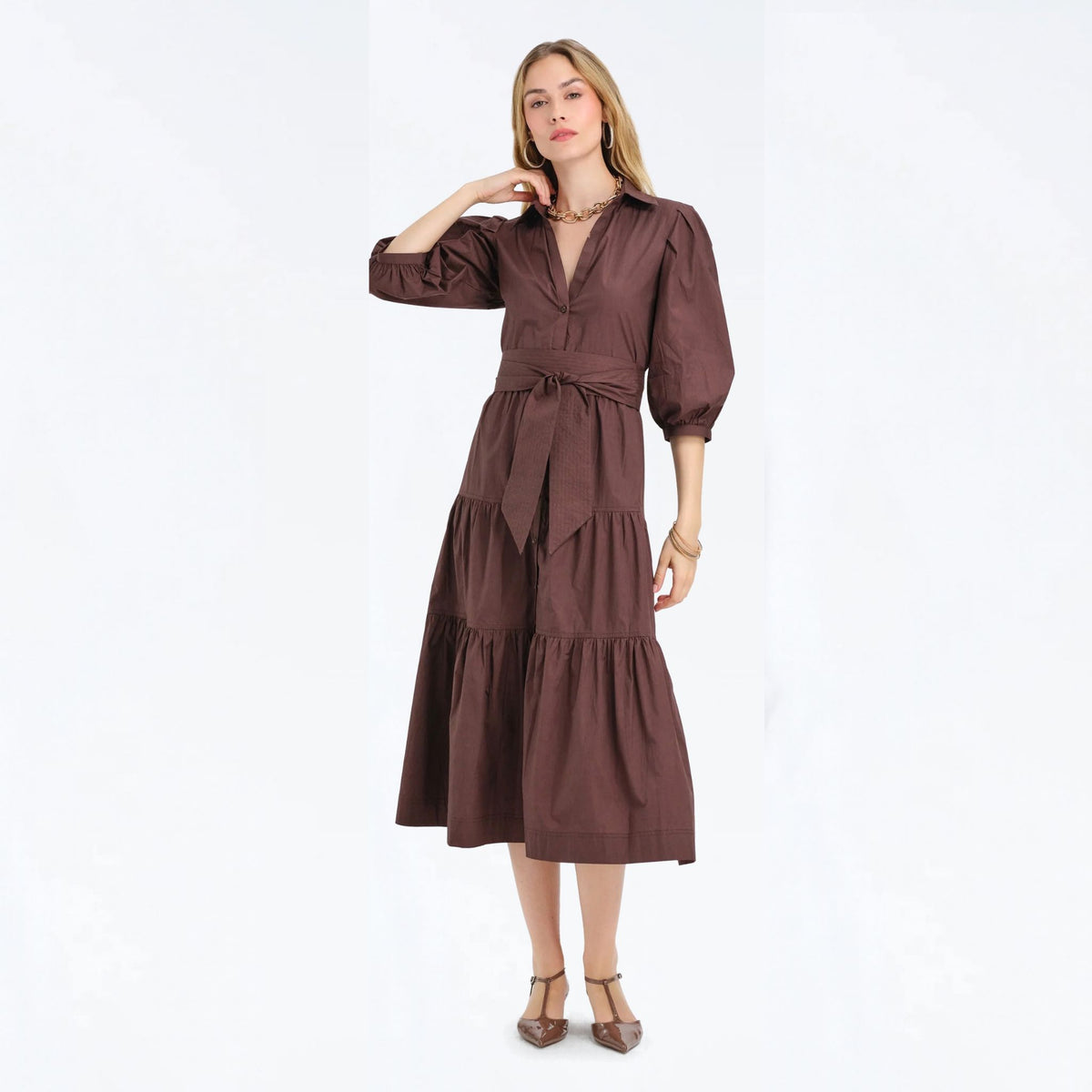Woman wearing a cocoa brown tiered maxi shirtdress with puff sleeves, full-length front view