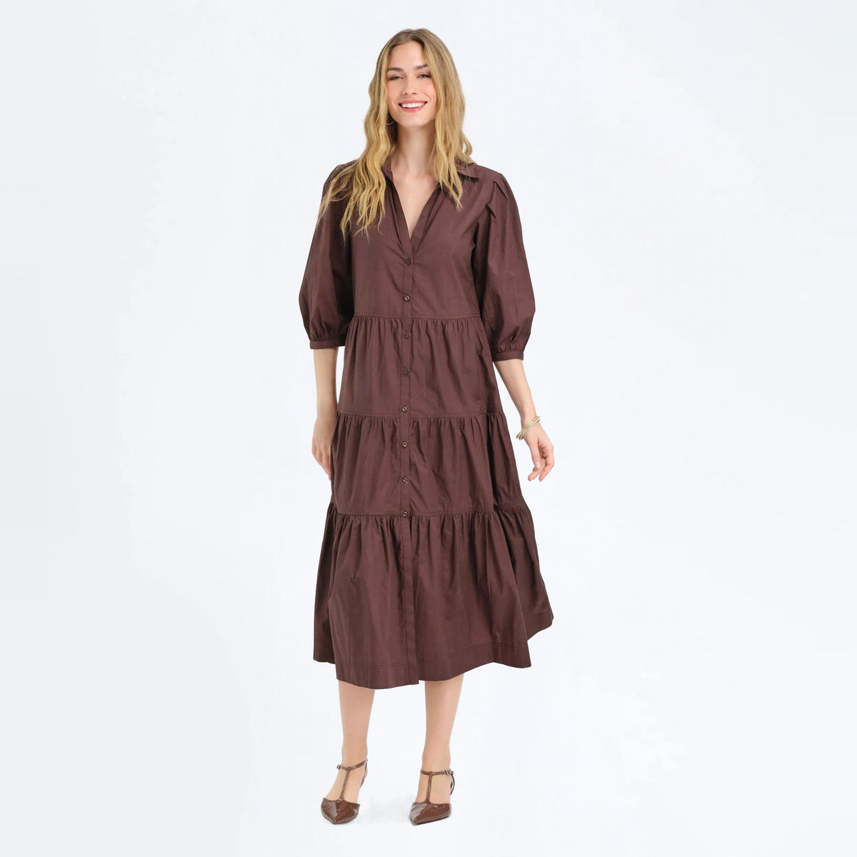 Woman standing in a cocoa brown button-front tiered maxi shirtdress