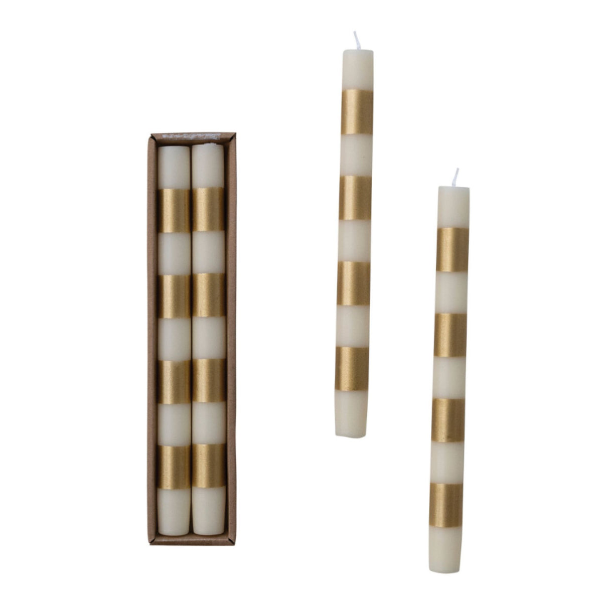 A pair of cream and metallic-gold striped taper candles standing upright, with two more candles laid beside a slim brown box.