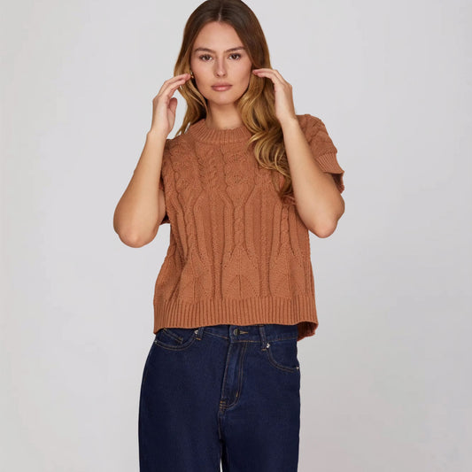 Front view of a cinnamon-colored cable knit sweater with a drop-shoulder fit.