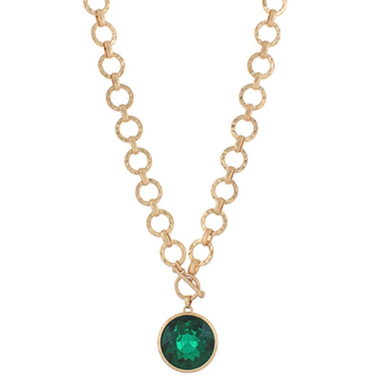 Gold necklace with a green gemstone pendant on a white background