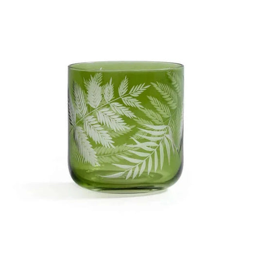 Green glass tumbler with white leaf pattern on a white background