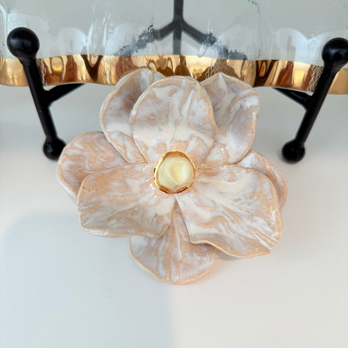 Handcrafted ceramic magnolia flower dish with ivory and cream marbled glaze and a gold-rimmed accent