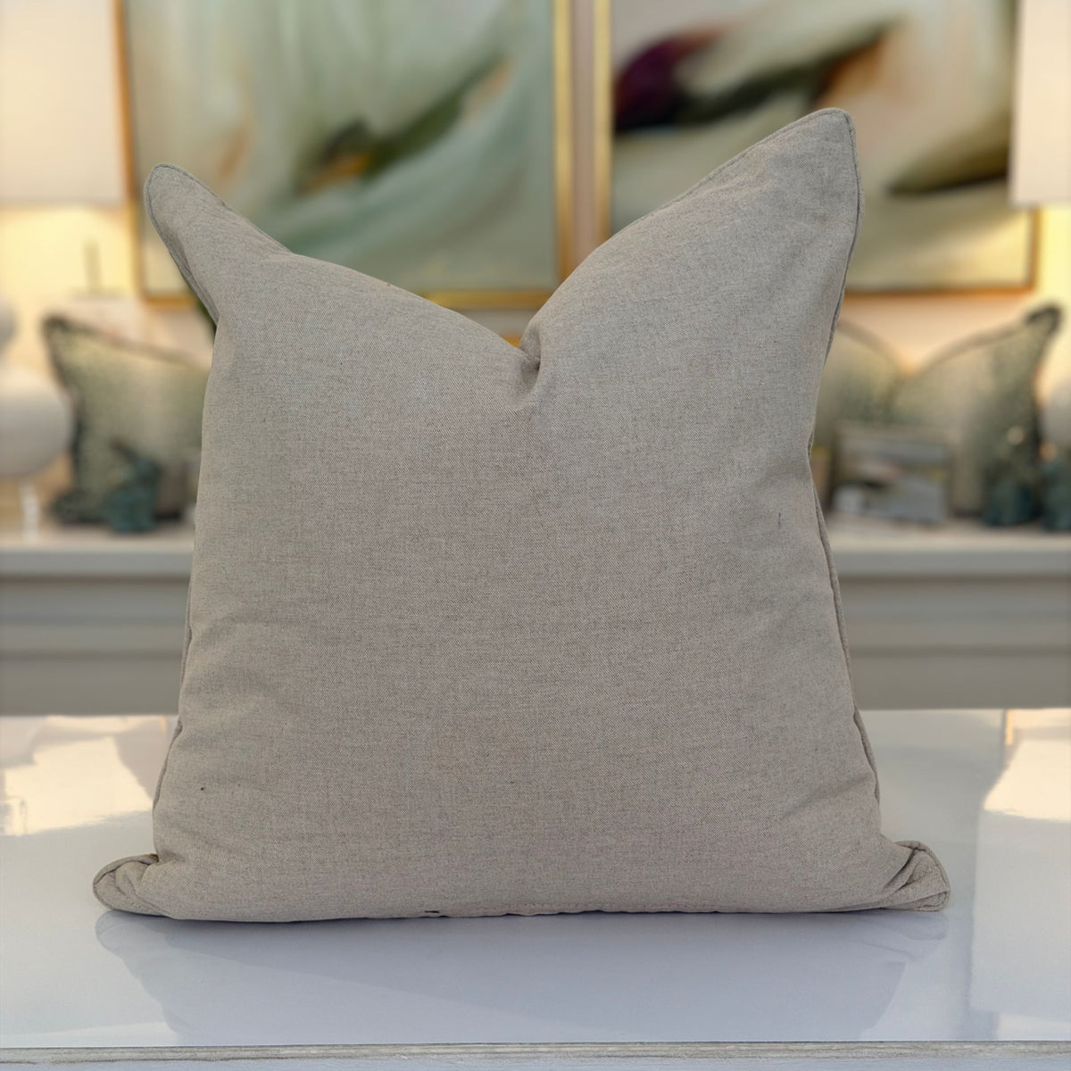 The plain taupe linen back of the green leopard print pillow.