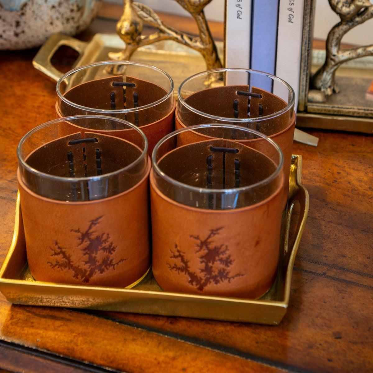 Lake Martin Rock Glasses with leather sleeves hand-stamped with the shape of Lake Martin, styled on a tray