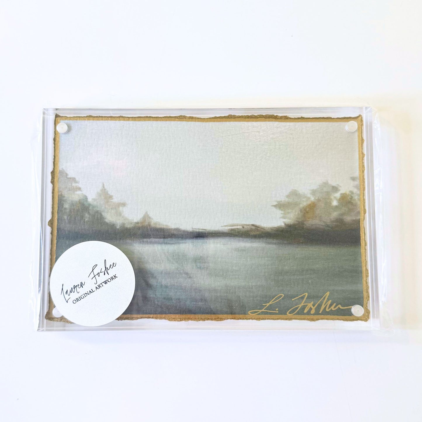 Lauren Foshee signed watercolor print, moody grey lake landscape with treeline silhouette, in a clear acrylic floating frame
