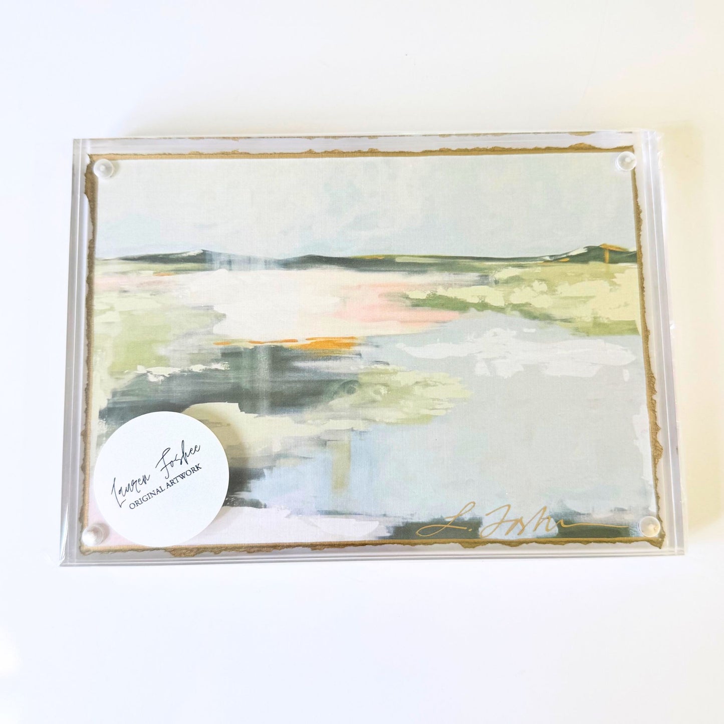 Lauren Foshee signed watercolor print, abstract marsh landscape in soft greens, blues, and warm sunset tones, in a clear acrylic floating frame