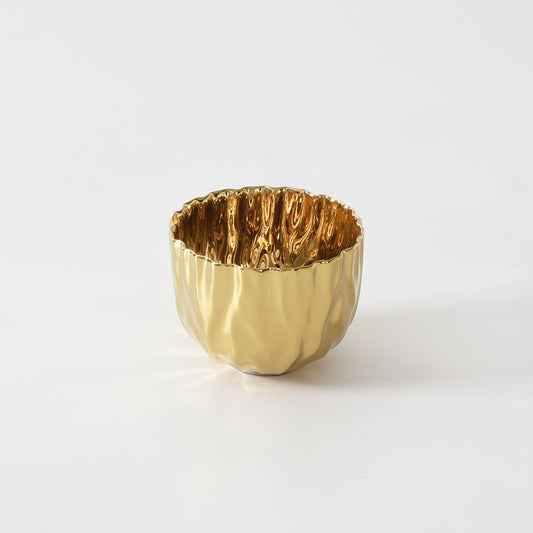 A small metallic gold snack bowl with a textured, hammered finish, photographed on a seamless white background.