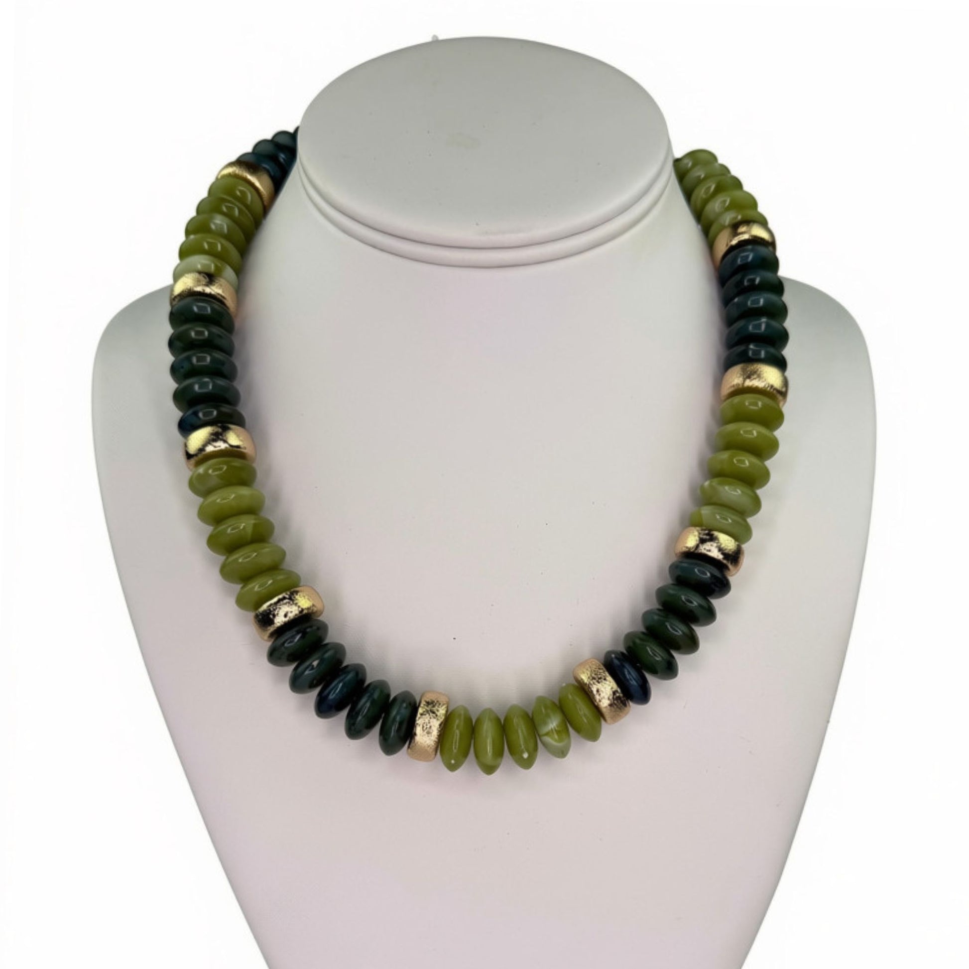 A beaded necklace displayed on a white jewelry bust. The necklace features alternating sections of polished olive green beads, dark forest green beads, and textured metallic gold spacer rings.