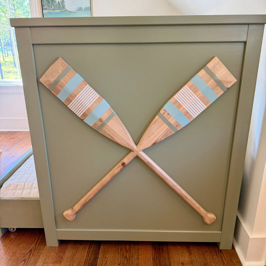 Footboard detail of the sage-green oar-inspired trundle bed.