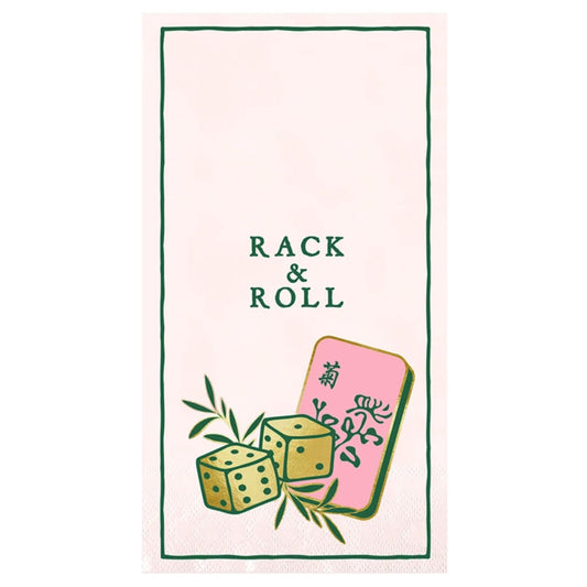 A pink paper guest towel printed with "Rack & Roll" in green script, a pair of gold dice, and a pink mahjong tile.