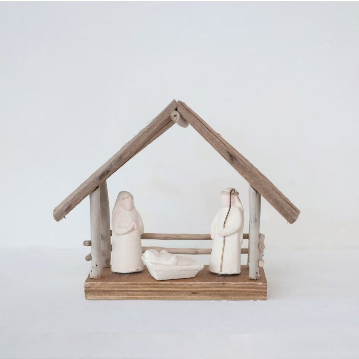 Close-up of the driftwood and paper mache nativity figures on a natural wood base.