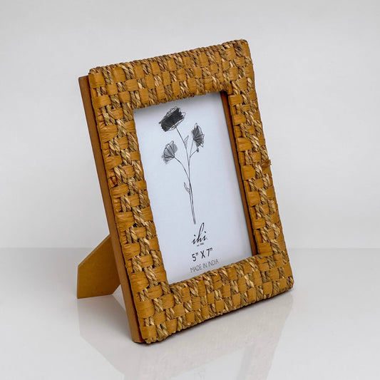 A 5x7 picture frame with a textured, woven mustard-yellow frame and a small matching stand, shown on a clean white background.