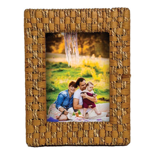A rectangular woven picture frame in natural tan and brown tones, shown on a white background with a sample family photo inserted in the center.