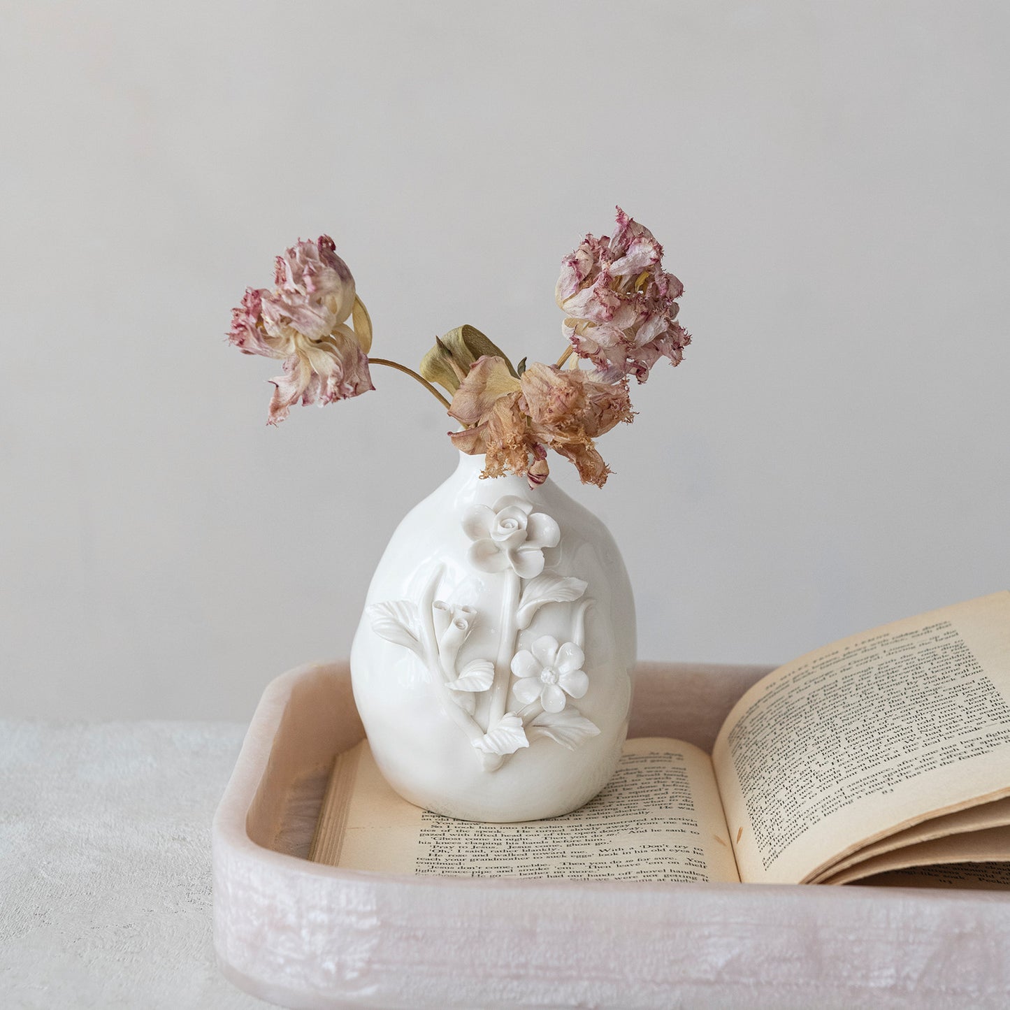 Sculptural white stoneware flower vase with raised floral motifs, close-up