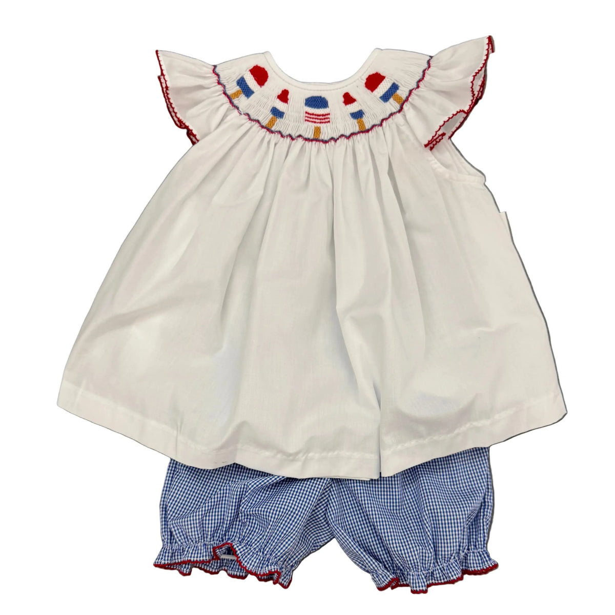 A white angel-sleeve baby top with a smocked yoke hand-embroidered with red, white, and blue popsicles, shown with navy gingham bloomers.