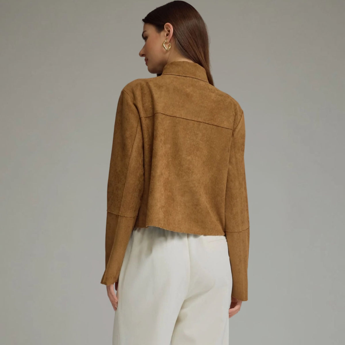 Back view of a cropped camel faux suede jacket.