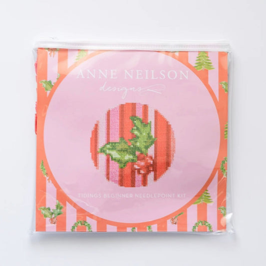 Tidings Beginner Needlepoint Kit packaging, featuring a holly and mistletoe design on an orange and pink striped background.