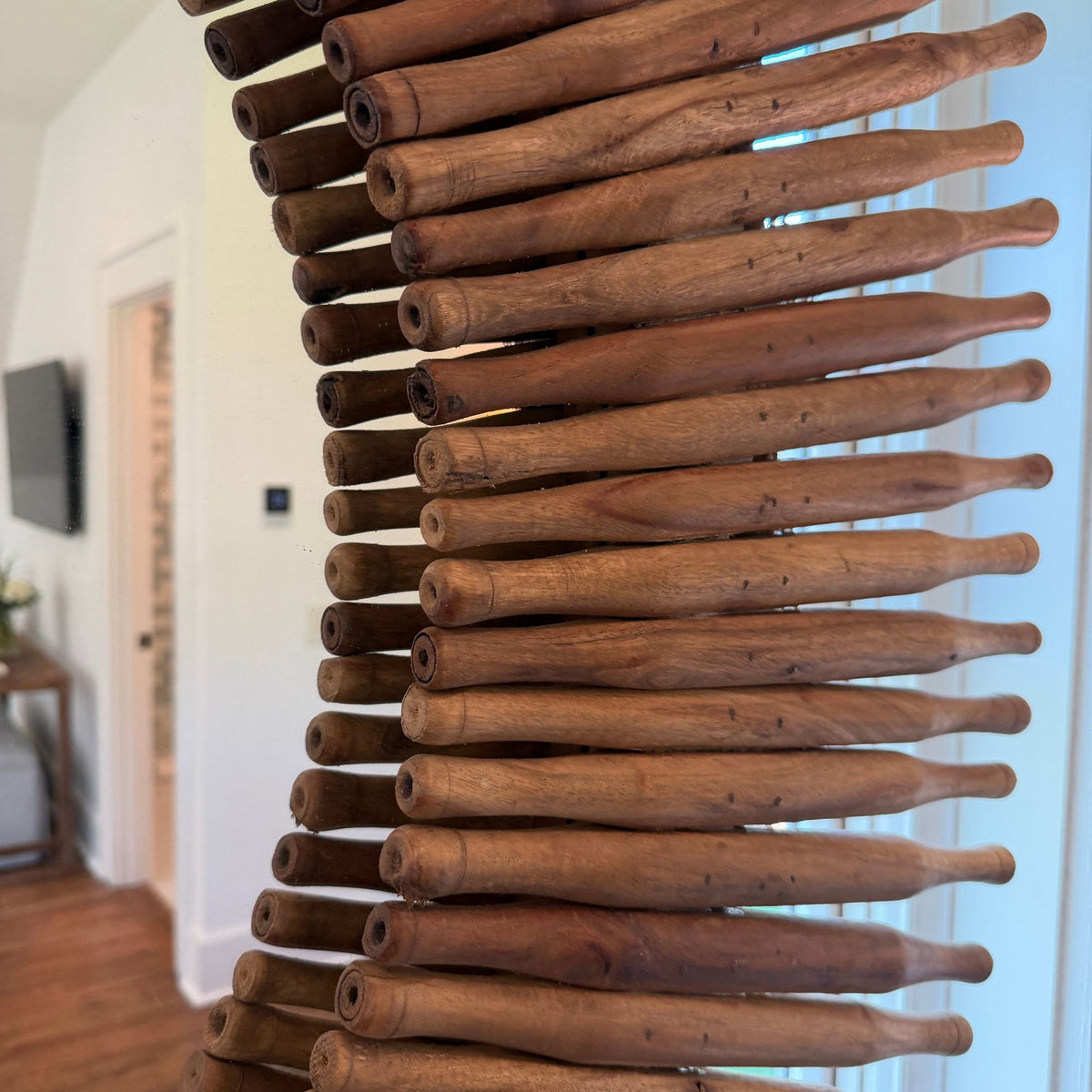 Close-up of the vintage rolling pin mirror's wooden sunburst frame