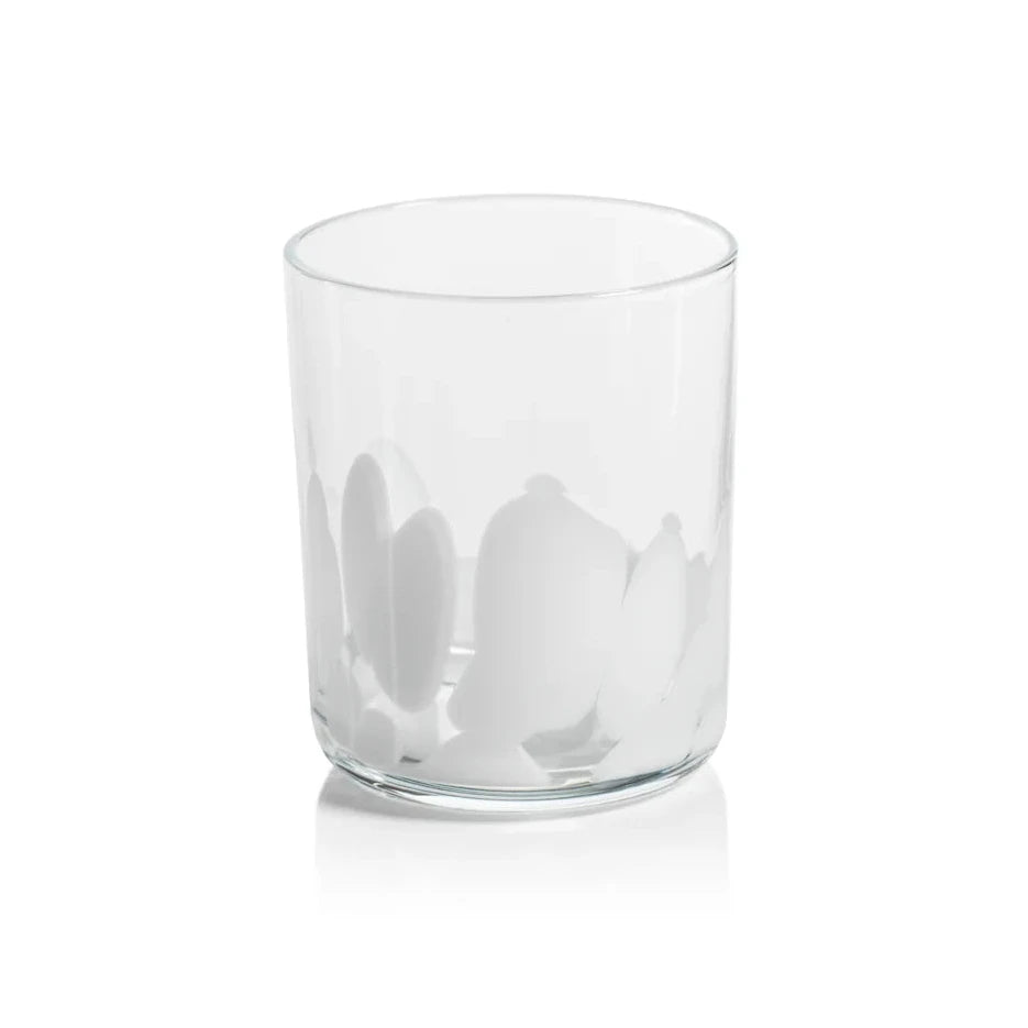 A clear glass tumbler with white spotted pattern near the base, shown on a clean white background with a soft reflection.