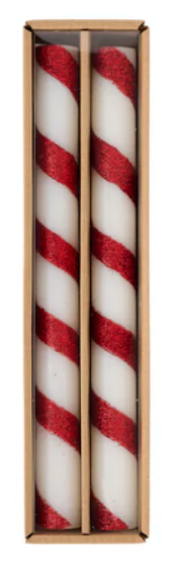 A boxed set of two white taper candles with glittered red candy-cane stripes.