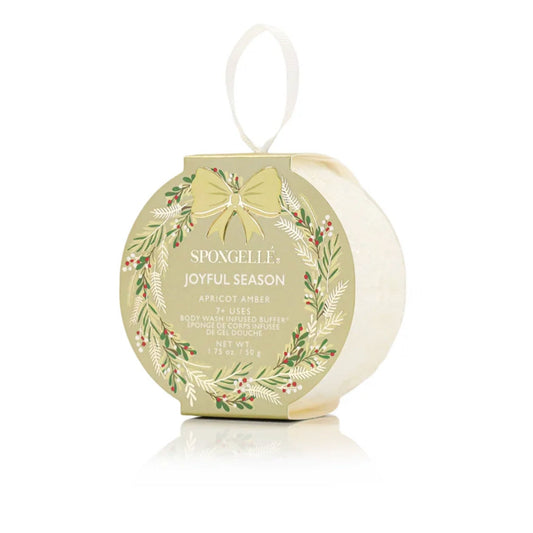 A gold wreath-shaped 'Joyful Season' body buffer box with a cream ribbon, labeled Apricot Amber