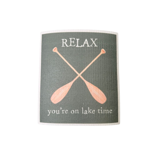 A gray Swedish dishcloth printed with crossed oars and the words 'Relax, you're on lake time.'
