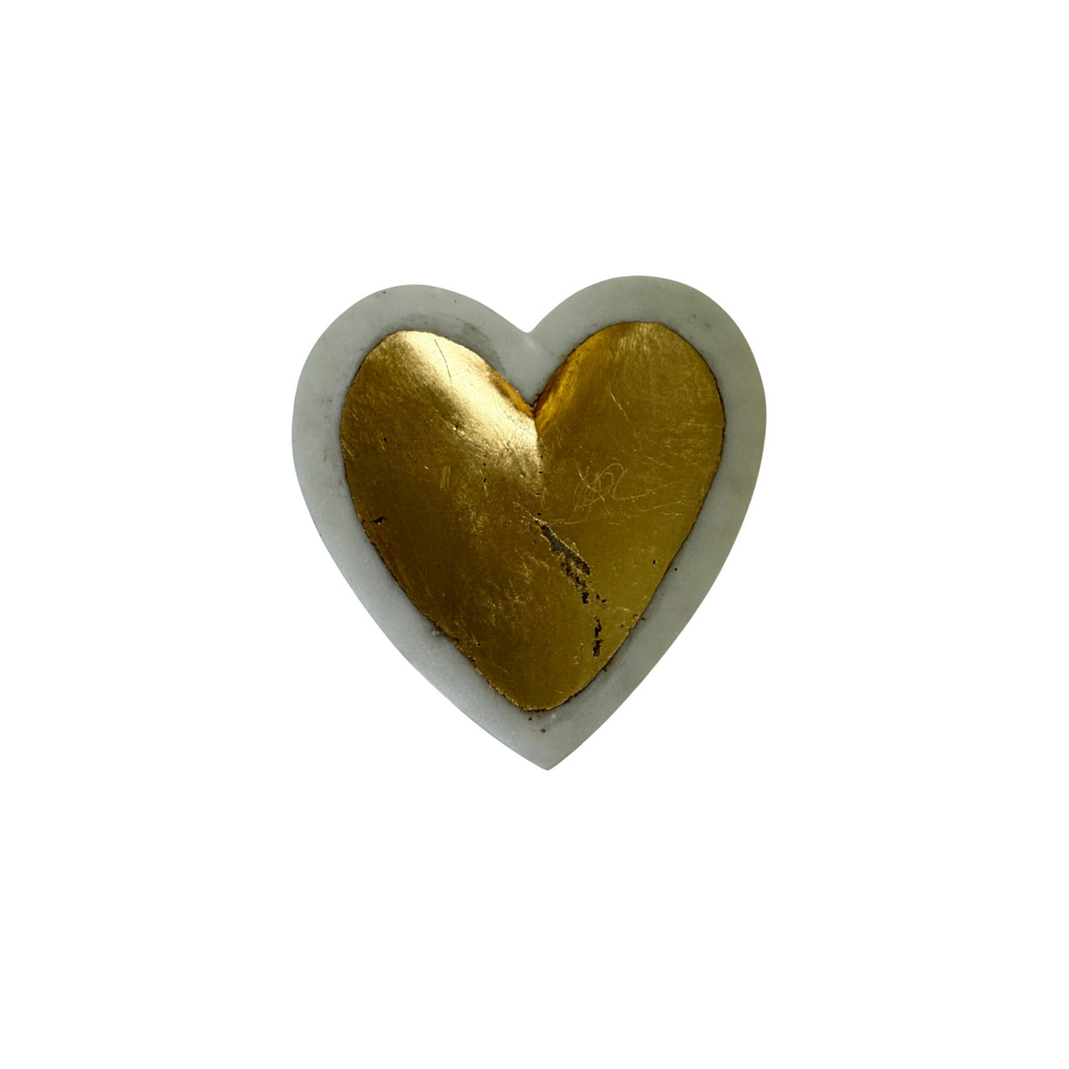 A heart-shaped white marble dish with a gold-leafed interior.