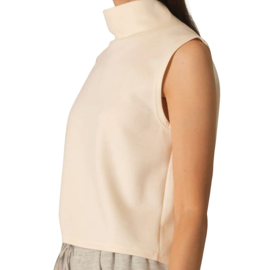 Close-up side view of an ivory sleeveless top with a stand-up cowl neckline, in a soft knit fabric.