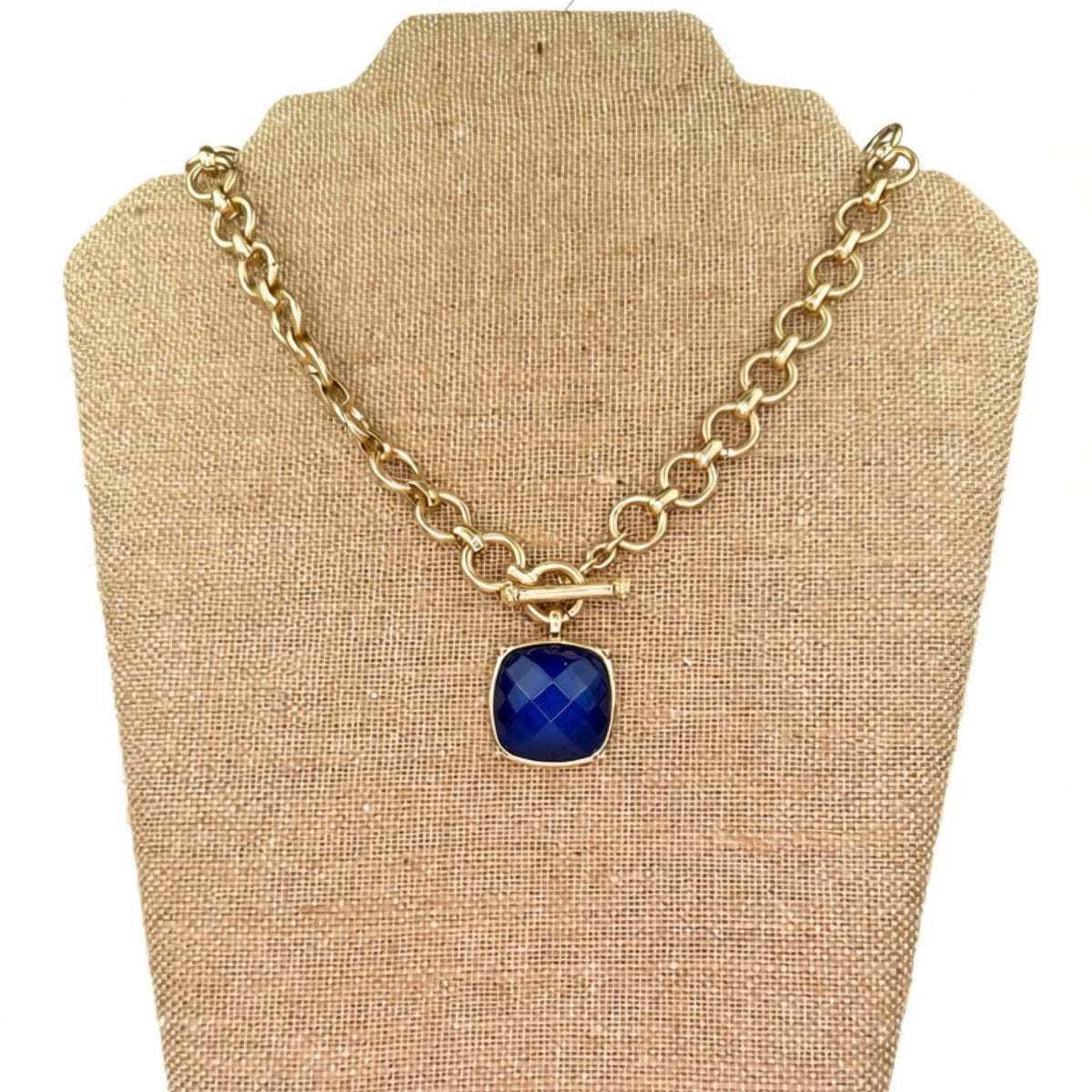 Gold chain-link necklace with a toggle clasp and stone pendant