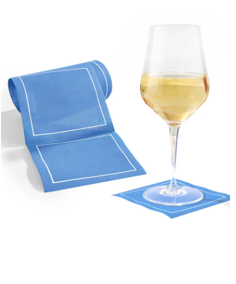 Blue napkin with white border next to a glass of white wine on a white background