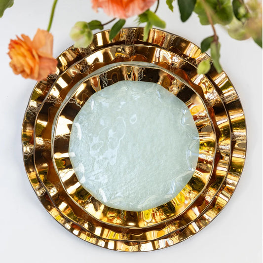 Ruffled glass buffet plate styled on a table, metallic gold rim
