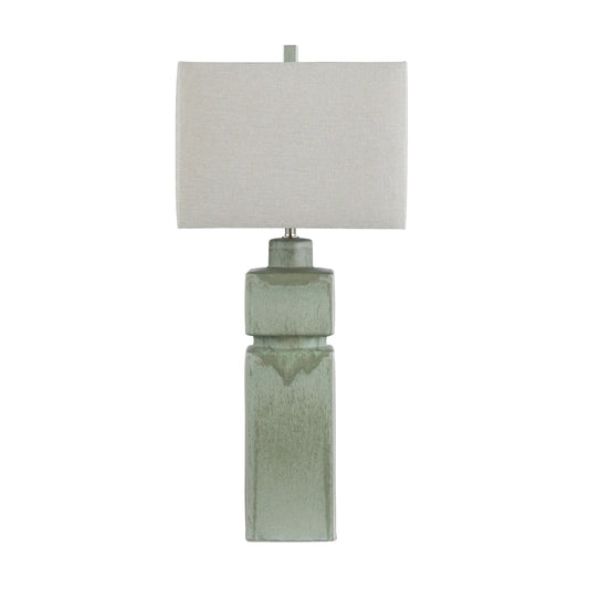 Green table lamp with textured base and rectangular white shade on a white background